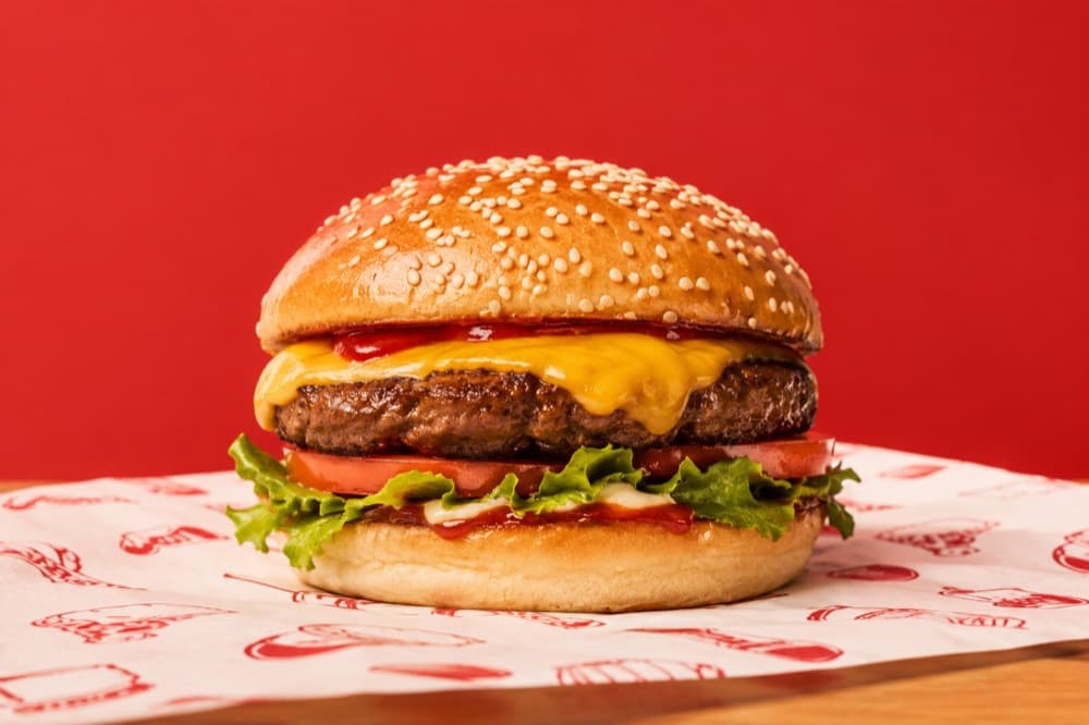 Beef burger with cheese on a red background